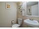 Charming powder bath with pedestal sink, toilet, and decorative shelves and artwork at 6936 S Knolls Way, Centennial, CO 80122