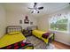 Cheerful bedroom with twin beds, ceiling fan, plush rug, and large window at 6936 S Knolls Way, Centennial, CO 80122