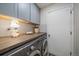 Convenient laundry room with washer, dryer, butcher block countertops, and subway tile backsplash at 6936 S Knolls Way, Centennial, CO 80122