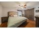 Comfortable main bedroom boasts wood floors, ceiling fan, and rustic sliding barn door at 6936 S Knolls Way, Centennial, CO 80122