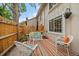 Cozy outdoor patio features wicker furniture, a striped rug, a decorated fence, and a beautiful view at 6936 S Knolls Way, Centennial, CO 80122