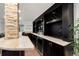 Basement bar with granite countertop and dark wood cabinets at 7475 W Kentucky Ave, Lakewood, CO 80226