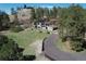 Aerial view of a home with long driveway, lawn, rock outcroppings and mature trees at 1559 Apex Rd, Franktown, CO 80116