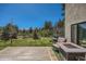 Spacious backyard featuring a fire pit, lounge seating, and lush landscaping at 1559 Apex Rd, Franktown, CO 80116