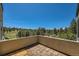 A balcony with beautiful views of trees, meadow, and sky on a sunny day at 1559 Apex Rd, Franktown, CO 80116