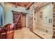 Bathroom featuring rustic stone shower, free standing tub, and custom sliding barn door at 1559 Apex Rd, Franktown, CO 80116