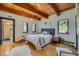 Cozy bedroom featuring wood beam ceilings, a comfortable bed, and bright natural light at 1559 Apex Rd, Franktown, CO 80116