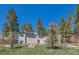 Contemporary home nestled among tall pine trees features clean lines and well-maintained landscaping at 1559 Apex Rd, Franktown, CO 80116