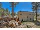Exterior view of home with a wood pile and views of surrounding woods at 1559 Apex Rd, Franktown, CO 80116