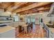Spacious kitchen boasting an island dining table, stainless steel appliances, and terra cotta floors at 1559 Apex Rd, Franktown, CO 80116