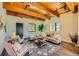 Charming living room featuring wood ceilings, a comfortable sofa, and a decorative rug, perfect for relaxation at 1559 Apex Rd, Franktown, CO 80116