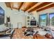 Cozy living room featuring beamed ceilings, a fireplace, terracotta tile flooring, and sliding glass doors at 1559 Apex Rd, Franktown, CO 80116