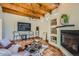Comfortable living room features a beamed ceiling, fireplace, and unique décor at 1559 Apex Rd, Franktown, CO 80116