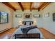 Serene bedroom with hardwood floors, wood ceiling beams, and ample light creating a warm and inviting atmosphere at 1559 Apex Rd, Franktown, CO 80116