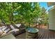 Beautiful back deck featuring a stone fire pit, comfy seating, and mature trees at 10345 Lions Heart, Lone Tree, CO 80124