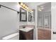 Powder room featuring a single sink vanity, framed mirror, and tiled backsplash at 10345 Lions Heart, Lone Tree, CO 80124