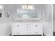 Bathroom with dual sink vanity, marble countertops, and a large mirror at 10345 Lions Heart, Lone Tree, CO 80124