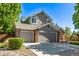 Traditional home boasts manicured lawn, a brick and grey exterior, and a driveway leading to a three-car garage at 10345 Lions Heart, Lone Tree, CO 80124