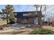 Brick building entrance surrounded by trees and featuring dormer windows and a gravel landscape at 100 E Highline Cir # 307, Centennial, CO 80122