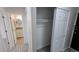 Hallway leading to a bathroom, with a closet featuring a hanging rod and sliding doors at 100 E Highline Cir # 307, Centennial, CO 80122