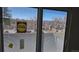 Window view with blinds overlooking a street, trees, and buildings on a sunny day at 100 E Highline Cir # 307, Centennial, CO 80122