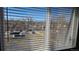 Window view with blinds overlooking a parking lot, trees, and buildings at 100 E Highline Cir # 307, Centennial, CO 80122