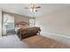 Spacious bedroom featuring neutral tones, a ceiling fan, and ample natural light from two windows at 1330 Conifer Pl, Elizabeth, CO 80107