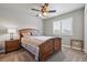 Comfortable bedroom featuring a wooden bed frame, side table, window, and ceiling fan at 1330 Conifer Pl, Elizabeth, CO 80107