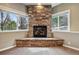 Stone fireplace with black trim, and views from two large windows on either side providing natural light at 1330 Conifer Pl, Elizabeth, CO 80107