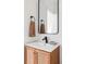 Stylish bathroom vanity features a wood cabinet, white countertop, black faucet, and a sleek black-framed mirror at 9542 Cherry St, Thornton, CO 80229