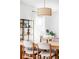 Bright dining room with modern light fixture, wood table, upholstered chairs, and large windows at 9542 Cherry St, Thornton, CO 80229