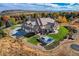 Expansive property featuring a pool, hot tub, lush lawn, and a three-car garage, set among mature trees at 13 Tamarade Dr, Littleton, CO 80127