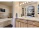 Bathroom featuring tiled walls, a large mirror, and a view into another bedroom at 13 Tamarade Dr, Littleton, CO 80127