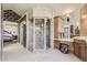 Bright bathroom featuring a glass enclosed shower, floral wallpaper, and neutral tile flooring at 13 Tamarade Dr, Littleton, CO 80127