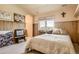 Cozy bedroom featuring paneled walls, a plush bed, and a window with scenic views at 13 Tamarade Dr, Littleton, CO 80127