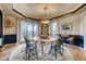 Elegant dining room with a round table, decorative rug, and natural light from surrounding windows at 13 Tamarade Dr, Littleton, CO 80127