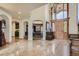 Spacious foyer with travertine floors, chandelier, and arched doorways leading to dining and living areas at 13 Tamarade Dr, Littleton, CO 80127