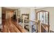 Bright hallway with hardwood floors, iron railing, and large window overlooking a landscape view at 13 Tamarade Dr, Littleton, CO 80127