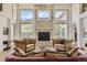 Comfortable living room showcasing a stone fireplace, multiple windows with scenic views, and plush seating at 13 Tamarade Dr, Littleton, CO 80127