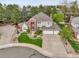 Aerial view of a beautiful home featuring mature landscaping, a three-car garage, and inviting curb appeal at 4220 S Yarrow Ct, Lakewood, CO 80235