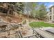Beautiful backyard featuring a rock waterfall feature, lush lawn, and patio seating area at 4220 S Yarrow Ct, Lakewood, CO 80235