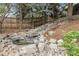 Landscaped backyard featuring a serene rock waterfall, mature trees, and privacy fence at 4220 S Yarrow Ct, Lakewood, CO 80235