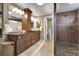 Bathroom featuring double sinks, wood cabinetry, and tiled shower at 4220 S Yarrow Ct, Lakewood, CO 80235