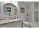 Bright bathroom boasts a granite vanity, round mirror, and subway tile shower-tub combo at 4220 S Yarrow Ct, Lakewood, CO 80235