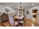 Inviting dining room featuring hardwood floors, a rustic chandelier, and views into the kitchen at 4220 S Yarrow Ct, Lakewood, CO 80235