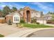 Beautiful two-story home featuring a brick facade, arched entryway, three-car garage, and well-maintained landscaping at 4220 S Yarrow Ct, Lakewood, CO 80235