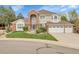Charming two-story home with a brick facade, arched entryway, three-car garage, and well-manicured front yard at 4220 S Yarrow Ct, Lakewood, CO 80235