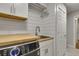 Convenient laundry room equipped with modern appliances, a sink, and ample storage space at 4220 S Yarrow Ct, Lakewood, CO 80235