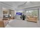 Comfortable living room featuring neutral decor, an aquarium, tray ceilings, and large windows with white shutters at 4220 S Yarrow Ct, Lakewood, CO 80235