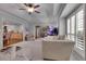 Spacious living room showcasing tray ceilings, neutral carpet and decor, large windows with white shutters, and an aquarium at 4220 S Yarrow Ct, Lakewood, CO 80235